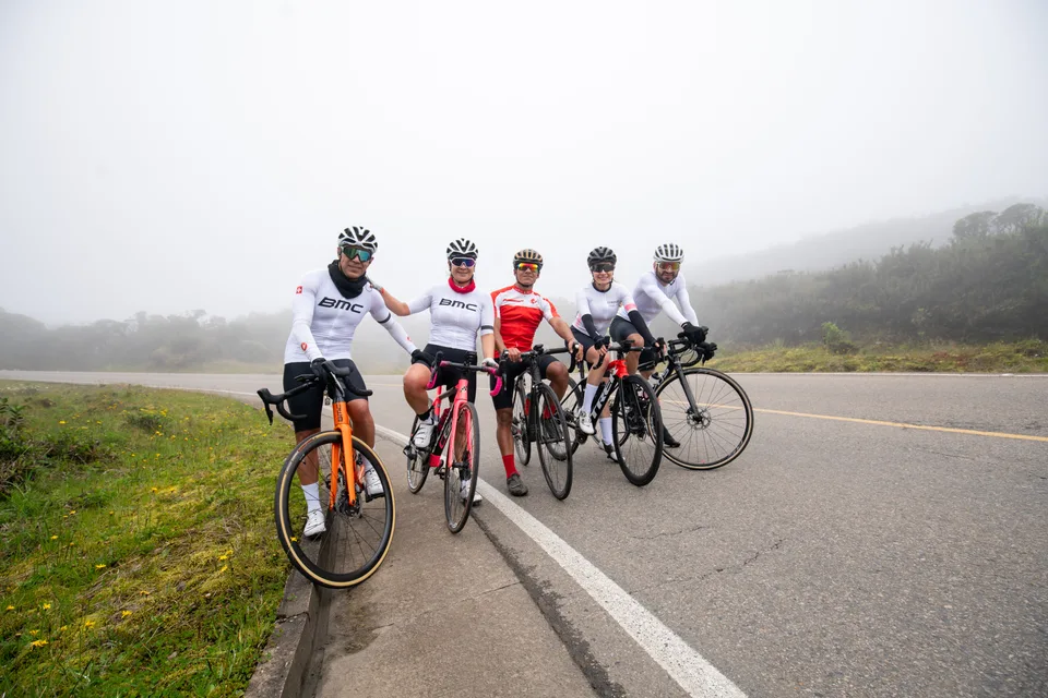 Ciclistas de ONE con sus bicicletas en una carretera de montaña con niebla