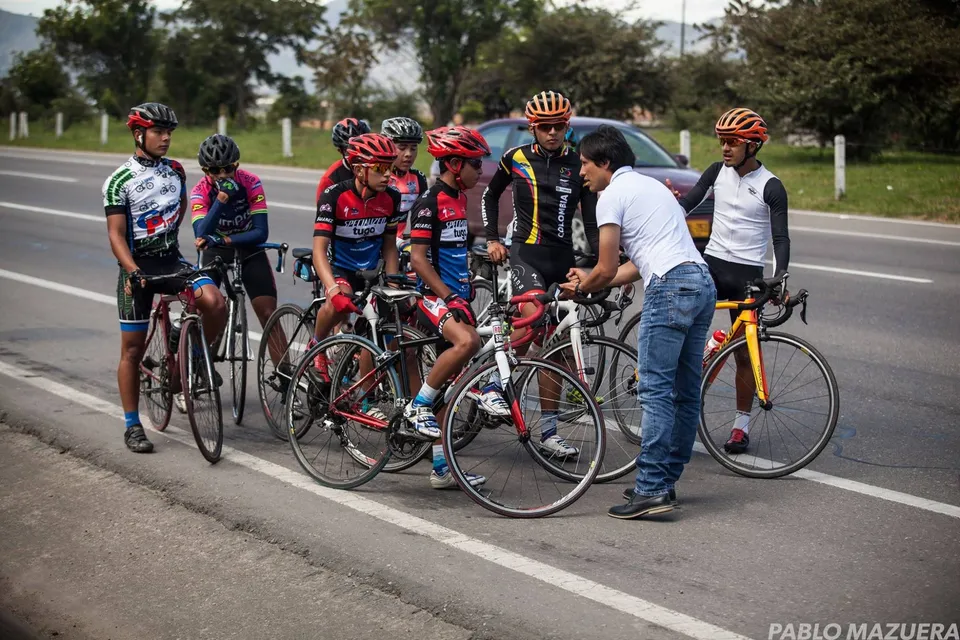 Edwin Castiblanco da indicaciones a un grupo de ciclistas juveniles en una carretera de la sabana de Bogotá
