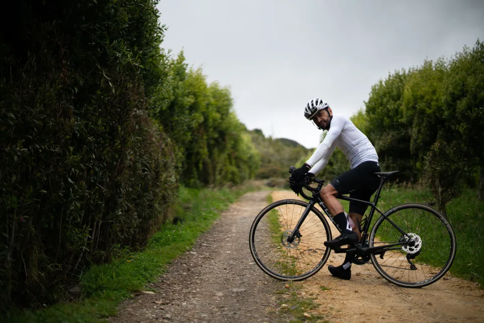 Ciclista sobre bicicleta de gravel en un camino de tierra suelta