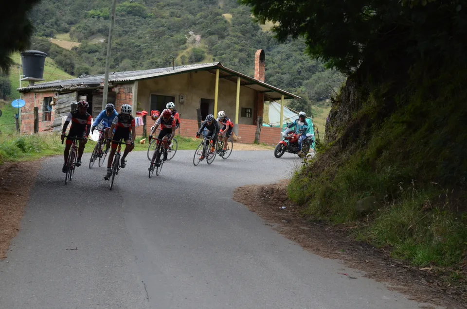 Grupo de ciclistas entrenando en una carretera rural de la sabana