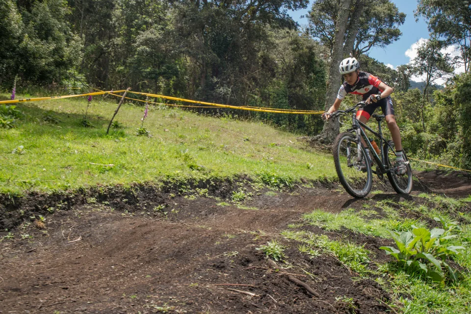 Ciclista de montaña coronando una subida de tierra en un sendero