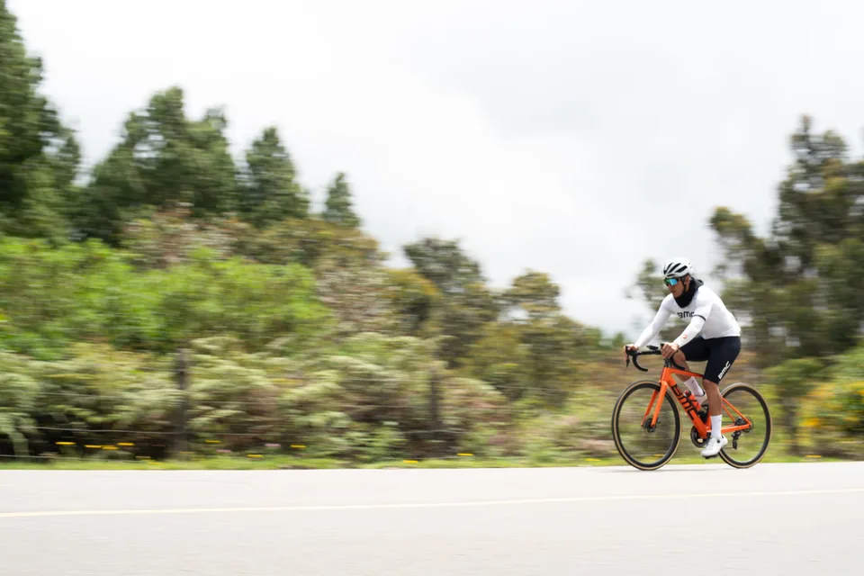 Ciclista de ONE sosteniendo el ritmo en una carretera abierta, con el fondo barrido por la velocidad
