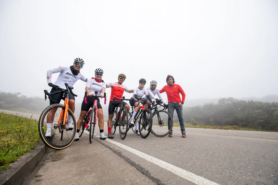Ciclistas de ONE con sus bicicletas en una carretera de montaña con niebla