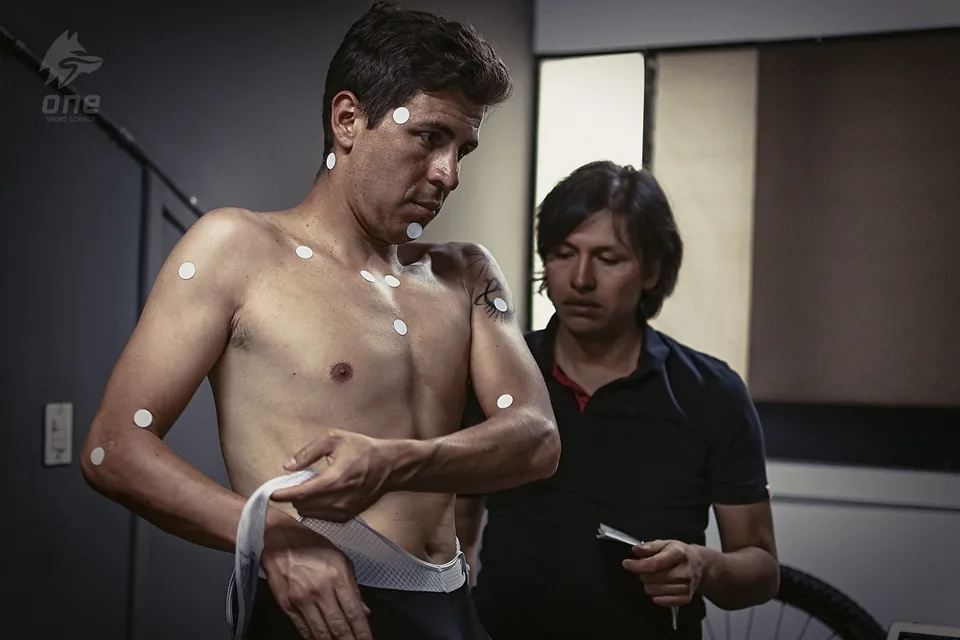 Edwin Castiblanco coloca marcadores sobre un ciclista antes de la evaluación en el laboratorio de ONE